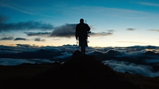 Ein Junge steht oben auf einem Berg.