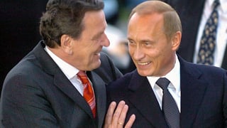 Gerhard Schröder umarmt lächelnden Wladimir Putin