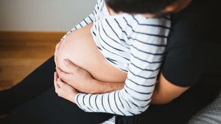 Eine Schwangere mit ihrem Partner. Er hält ihren Bauch. Eine Schwangere mit ihrem Partner. Er hält ihren Bauch.