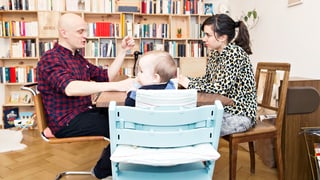 Mann und Frau am Tisch mit Baby