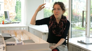 Eine Frau sitzt auf einem Stuhl und gestiluliert mit den Händen. Eine Frau sitzt auf einem Stuhl und gestiluliert mit den Händen.