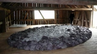 Eine Skulptur von Richard Long in einer Scheune.