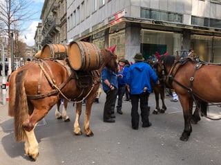 Männer warten mit Pferden in der Stadt.
