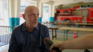 Mann mit Glatze spricht in Mikrofon. Mann mit Glatze spricht in Mikrofon.