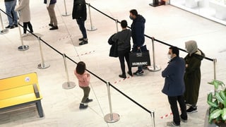 Menschen stehen Schlange in einem Einkaufszentrum.