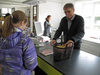 Regierungsrat Franz Enderli bedient eine junge Kundin in der Bibliothek. 