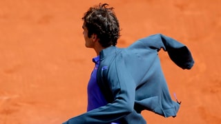 Roger Federer zieht seine Jacke an. 