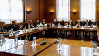 Regierungsvertreter sitzen in einem Sitzungszimmer an einem Tisch. Regierungsvertreter sitzen in einem Sitzungszimmer an einem Tisch.