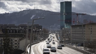 Autos fahren in Zürich am Prime Tower vorbei.