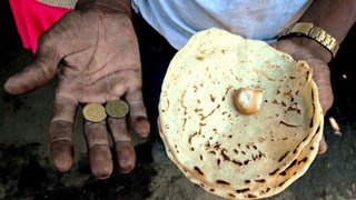 Ein Mann aus Nicaragua hält in der einen Hand Münzen, in der anderen ein Fladenbrot. Ein Mann aus Nicaragua hält in der einen Hand Münzen, in der anderen ein Fladenbrot.
