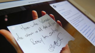 Screenshot: Auf einem iPad ist ein Foto auf Instagram zu sehen. Es zeigt eine Hand, die einen Zettel mit einem Gedicht hält.