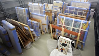 Zahlreiche verpackte Bilder stehen aufgestellt am Boden. Zahlreiche verpackte Bilder stehen aufgestellt am Boden.