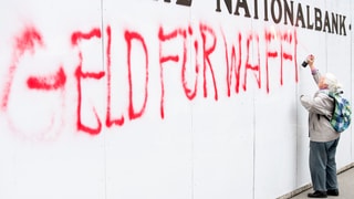 Betagte Frau versprayt weisse Wand mit Lettern «Geld für Waffen tötet»