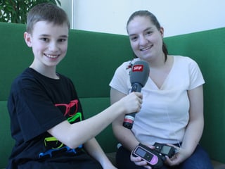 Der Junge Micha führt ein Interview mit Reporterin Giulia.