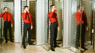 Vier Männer in Anzügen und Telefonkabinen. Vier Männer in Anzügen und Telefonkabinen.