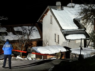 Ein Polizist steht vor dem Haus des Amoklaufs.