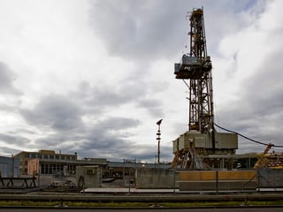 Ein Bohrturm in einer industriellen Landschaft.