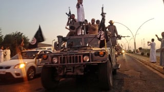 IS-Kämpfer paradieren auf einem Wagen der irakischen Sicherheitskräfte IS-Kämpfer paradieren auf einem Wagen der irakischen Sicherheitskräfte