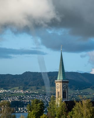Wasserhose über dem See neben einem Kirchturm.
