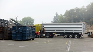 Lastwagen und Container stehen auf einem Recyclinghof