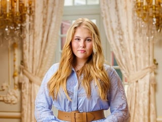 Amalia in goldenem Raum mit blauem Kleid.