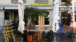Zusammengestellte Stühle und Tische vor der geschlossenen Cuba Bar.