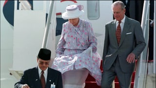 Die Queen und Philip steigen die Treppe aus ihrem Flugzeug hinunter.