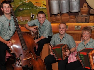 Drei Männer und eine Frau mit ihren Instrumenten: ein Kontrabass und drei Schwyzerörgeli.
