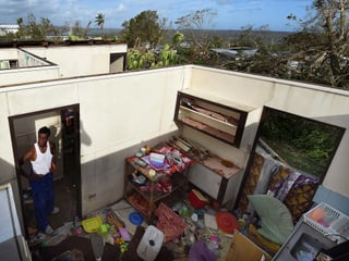 Ein Mann steht in seiner verwüsteten Wohnung ohne das Dach.