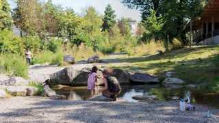 Ein Vater und seine Tochter an einem Teich im Park.