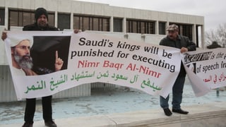 Zwei Männer halten ein Transparent, auf dem steht: "Saudi's king will be punished for executing" 