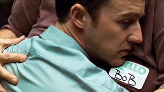 Filmszene: Norton umarmt einen sehr dicken Mann, auf dessen Shirt das Namensschild "Bob" klebt.