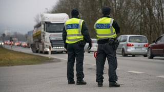 Zwei Polizisten von hinten fotographiert.