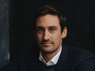 Nahaufnahme von Guillaume Pousaz mit verschrenkten Armen auf einem Stuhl.