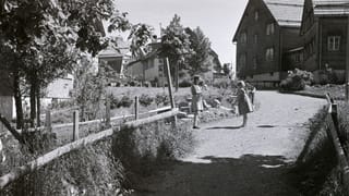 eine schwarz-weiss Fotografie von zwei Kindern inmitten Häusern und Garten eine schwarz-weiss Fotografie von zwei Kindern inmitten Häusern und Garten