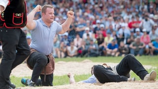 Christian Schuler feiert seinen Festsieg am Innerschweizer Schwing- und Älplerfest Anfang. Er kniet im Sagmehl und hat die Hände erhoben.