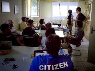Ein dunkler Keller, 30 Leute sitzen vor einer Leinwand und vefolgen eine Präsentation Ein dunkler Keller, 30 Leute sitzen vor einer Leinwand und vefolgen eine Präsentation