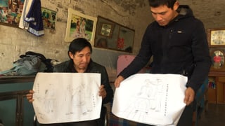 Sohn und Vater zeigen Zeichnungen der Foltermethoden
