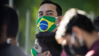 Ein Mann mit einer Maske mit Brasilien-Flagge