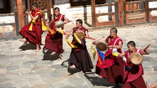 Männer in buddhistischer Kleidung mit Trommeln