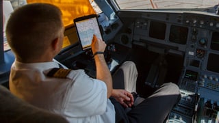 Pilot im Cockpit vor einem installiereten iPad.