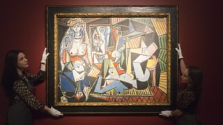 Zwei Frauen halten mit Handschuhen ein Picasso-Gemälde.