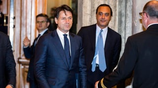Conte umringt von weiteren Männern. Conte umringt von weiteren Männern.