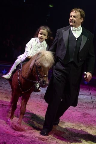Mann mit Frack und Mädchen auf Pony