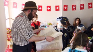 Mann in Appenzeller Kleidung liest aus Schriftrolle Mann in Appenzeller Kleidung liest aus Schriftrolle
