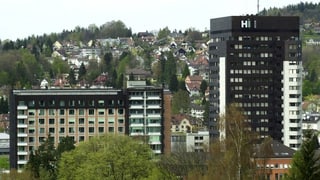 Blick auf zwei GEbäude, im Hintergrund eine Stadt