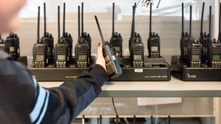 Eine Person bedient sich an einer grossen Auslage von Funktelefonen. Eine Person bedient sich an einer grossen Auslage von Funktelefonen.