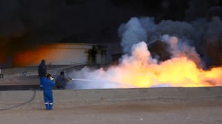 Feuer, Rauch, einige Männer mit Wasserschläuchen. Feuer, Rauch, einige Männer mit Wasserschläuchen.