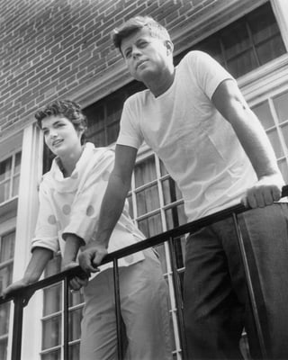 Jacqueline Kennedy neben JFK; Schwarz-Weiss-Fotografie auf einem Balkon stehend. Jacqueline Kennedy neben JFK; Schwarz-Weiss-Fotografie auf einem Balkon stehend.