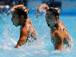 Schwimmerinnen mit Hand vor dem Gesicht.